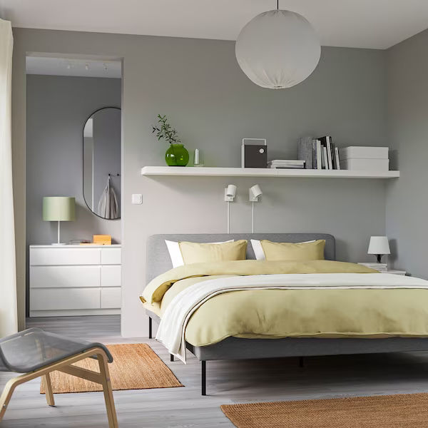 Dormitorio espacioso de estilo contemporáneo con alfombra blanca y paredes  y muebles de color gris claro.