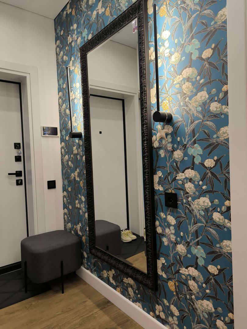 Tall mirror and vertical wallpaper accent in a compact entryway