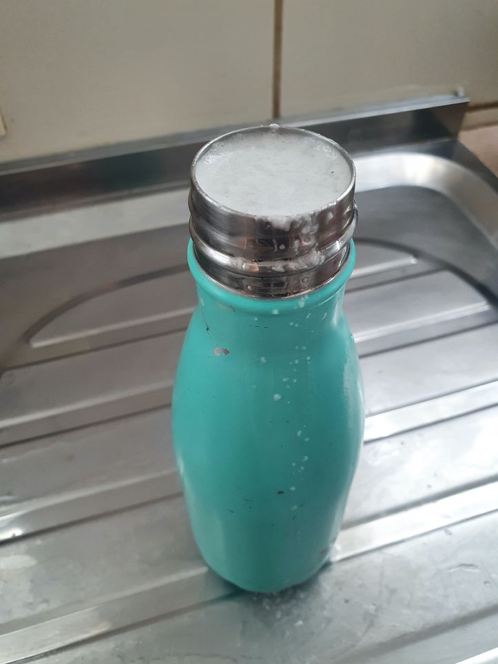 Trasparente umido pulire bottiglia di alcool con gocce isolati su