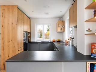 Moderne Rundküche mit Holzelementen und Steinoptik, Beer GmbH Beer GmbH Built-in kitchens